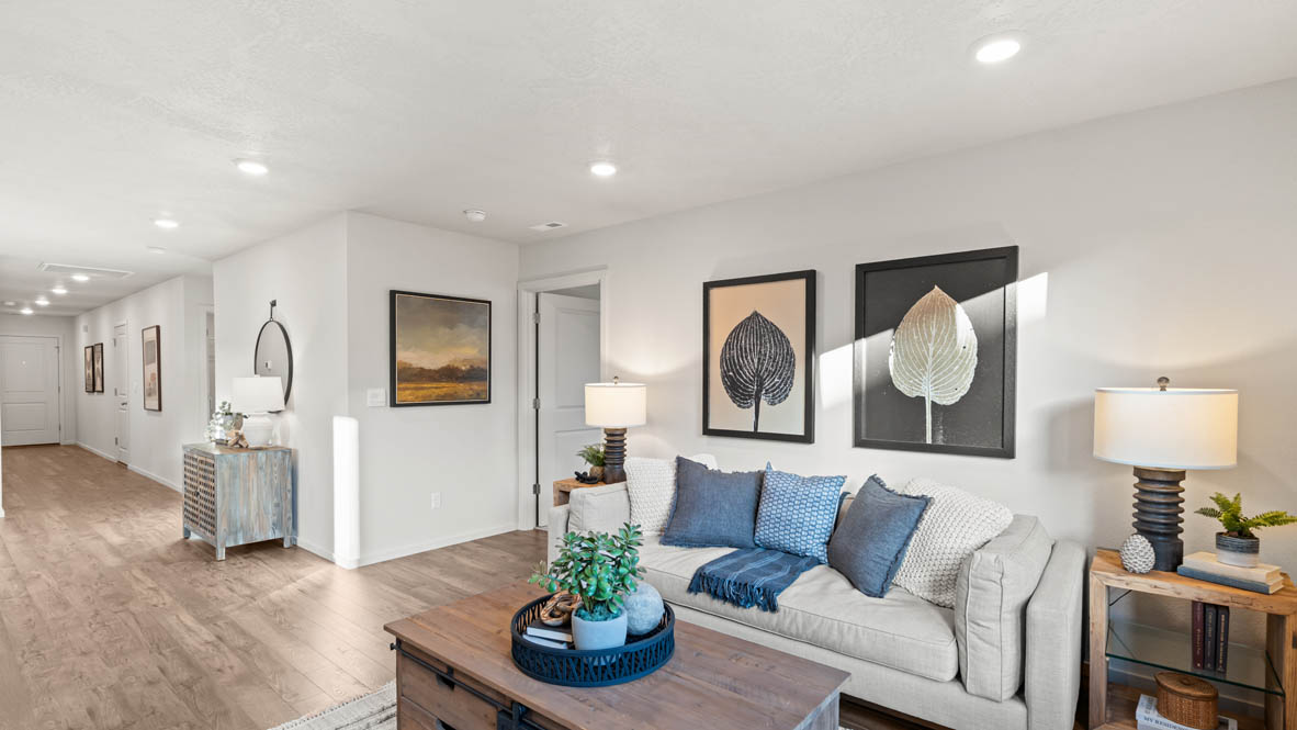 Addysen Park great room with an electric fireplace, couches, coffee table, windows, blinds, and flooring