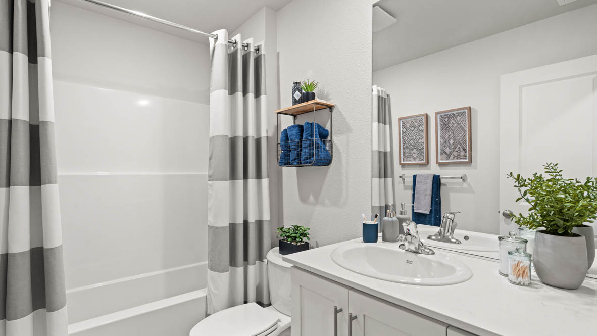 Addysen Park secondary bathroom with vanity, decorative art, mirror, quartz countertops, toilet