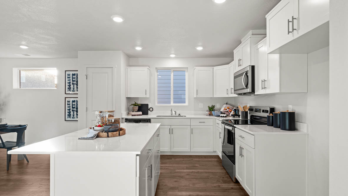 Addysen Park kitchen with island, quartz countertops, and the great room and dining in the background