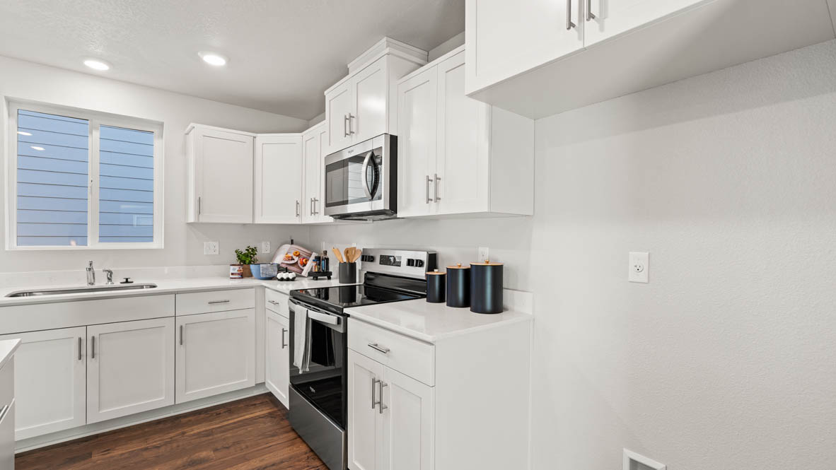 Addysen Park kitchen with island, quartz countertops, and the great room and dining in the background