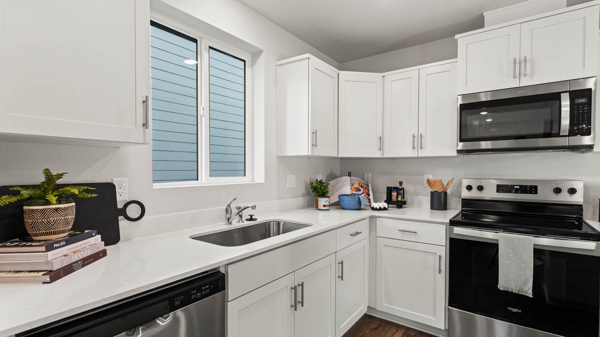 Addysen Park kitchen with island, quartz countertops, and the great room and dining in the background