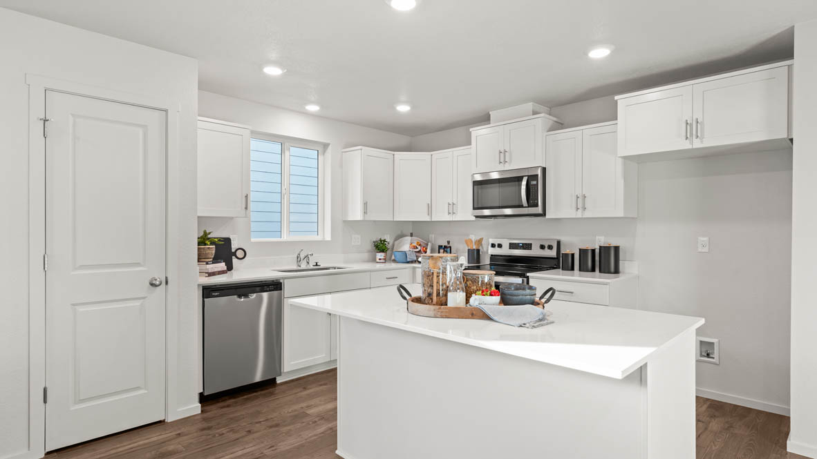 Addysen Park kitchen with island, quartz countertops, and the great room and dining in the background
