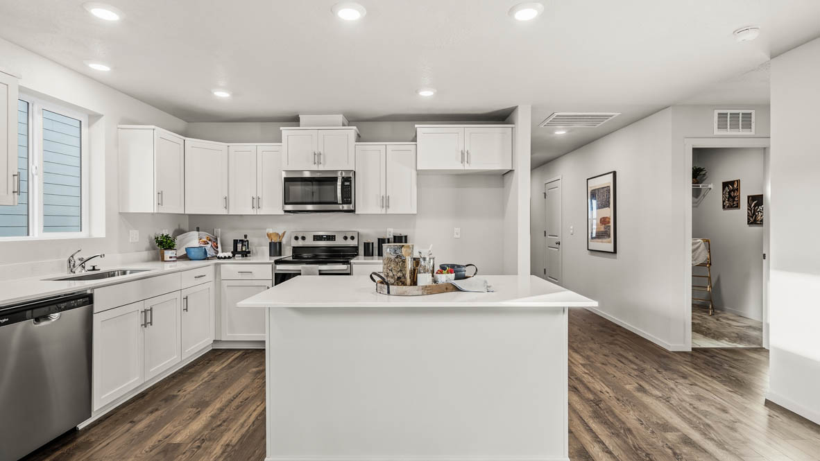 Addysen Park kitchen with island, quartz countertops, and the great room and dining in the background