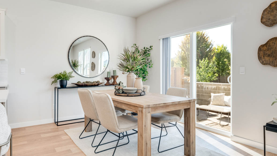 Avery Terrace Dining Room with four chairs, a table, a plant, sliding glass door, hanging decorations, a side table, a console table with plants and a mirror
