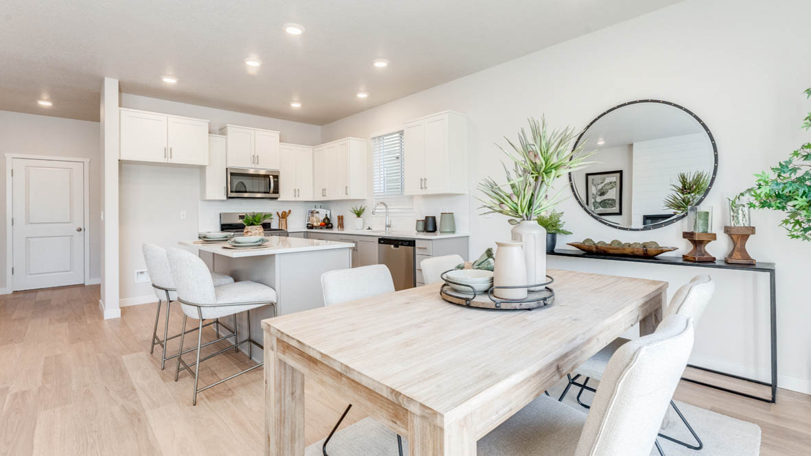 Avery Terrace Kitchen with island and a breakfast bar, two chairs, white cabinets, stainless steel appliances, quartz countertops, a window, decorations, and laminate flooring