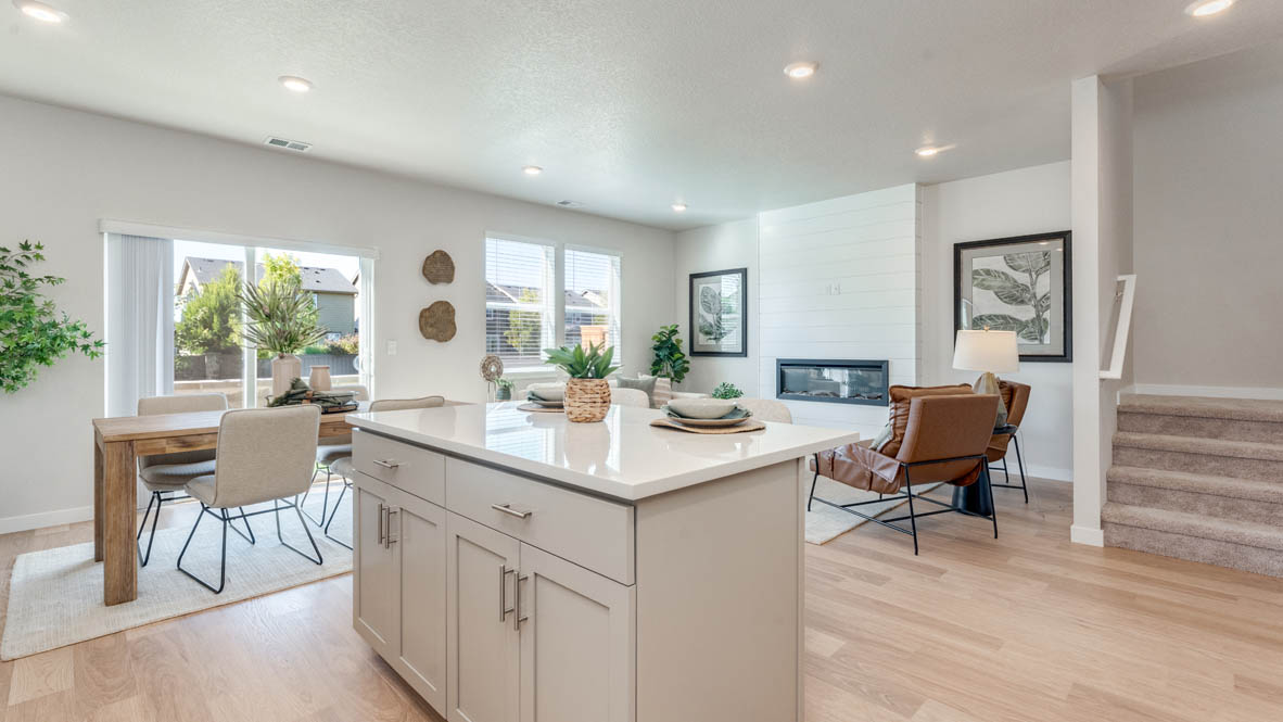 Avery Terrace Kitchen with white cabinets, an island with a breakfast bar, two chairs, and view of kitchen and dining room