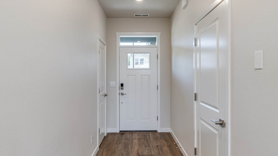 Avery Terrace Entry with a white door, laminate flooring, white walls, and bathroom