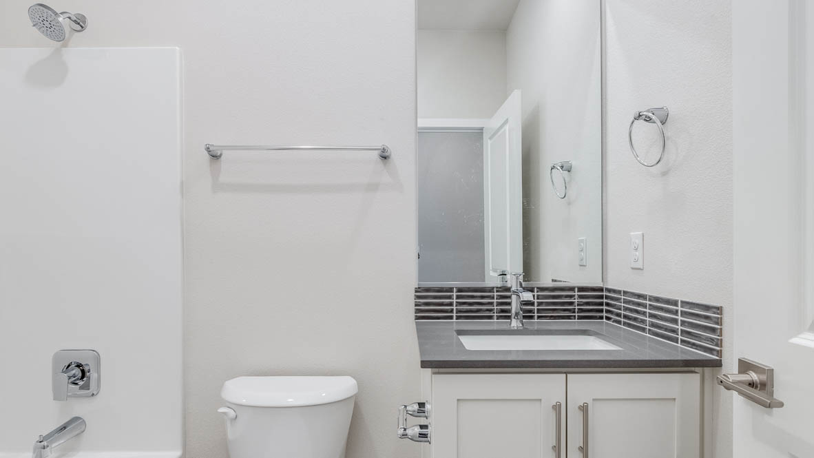Avery terrace Bathroom with a mirror, shower tub, toilet, sink, quartz countertops, and sink