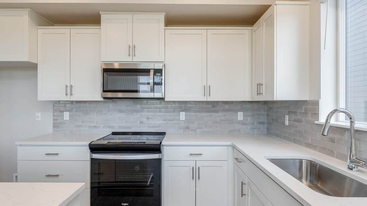 Avery Terrace Kitchen with quartz countertops, island, stainless steel appliances, cabinets, and a window