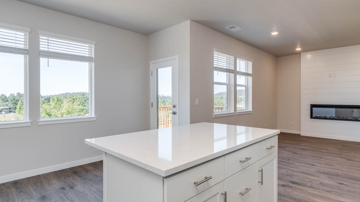 Avery Terrace kitchen with an island, windows, laminate flooring, and the great room in the background