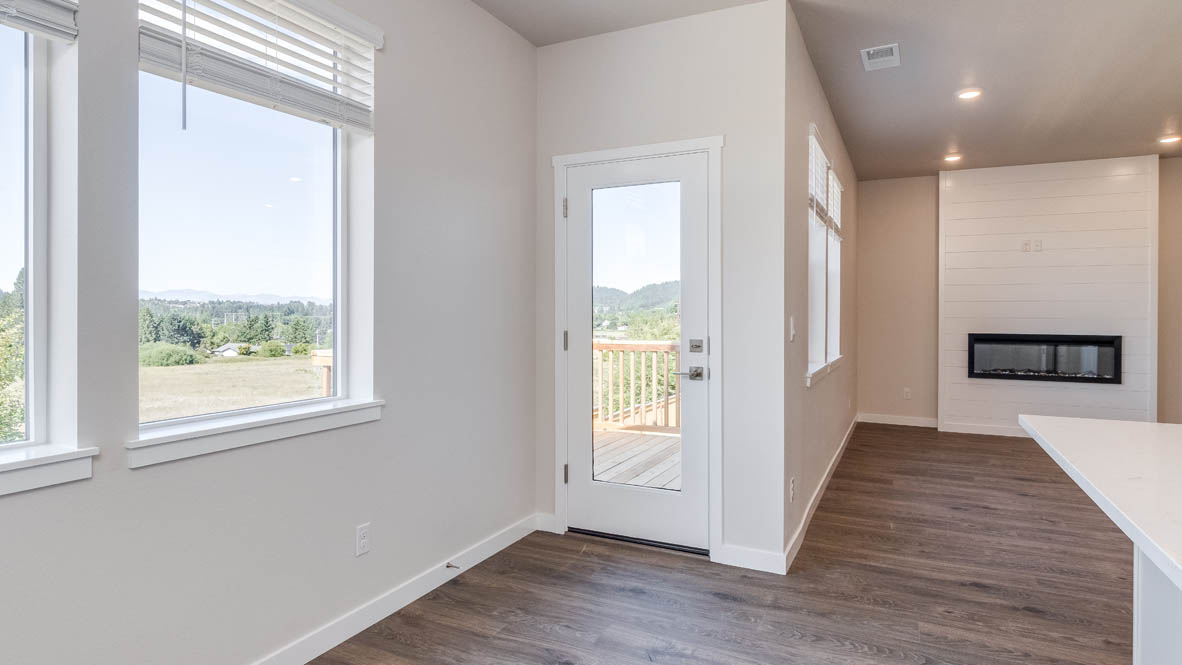 Avery Terrace dining room with laminte flooring, windows, door to the deck, and the great room in the background