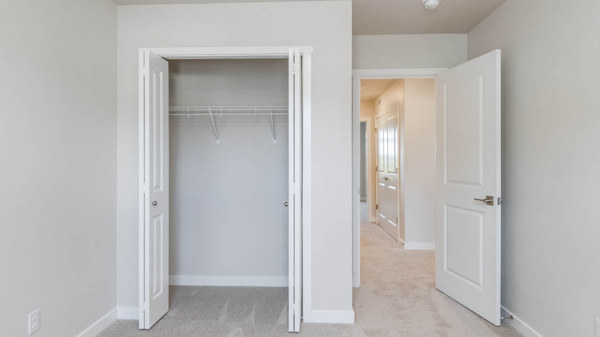 Avery Terrace bedroom with carpet, white walls, and a closet