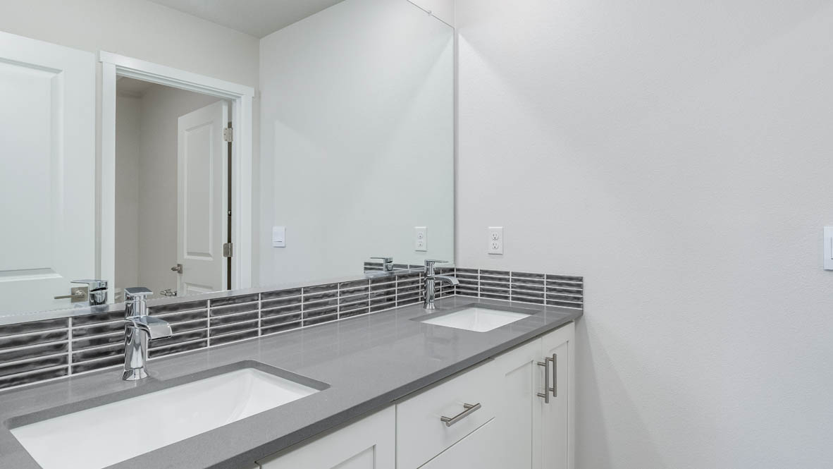 Avery Terrace bathroom with a double vanity sink and mirror, quartz countertops