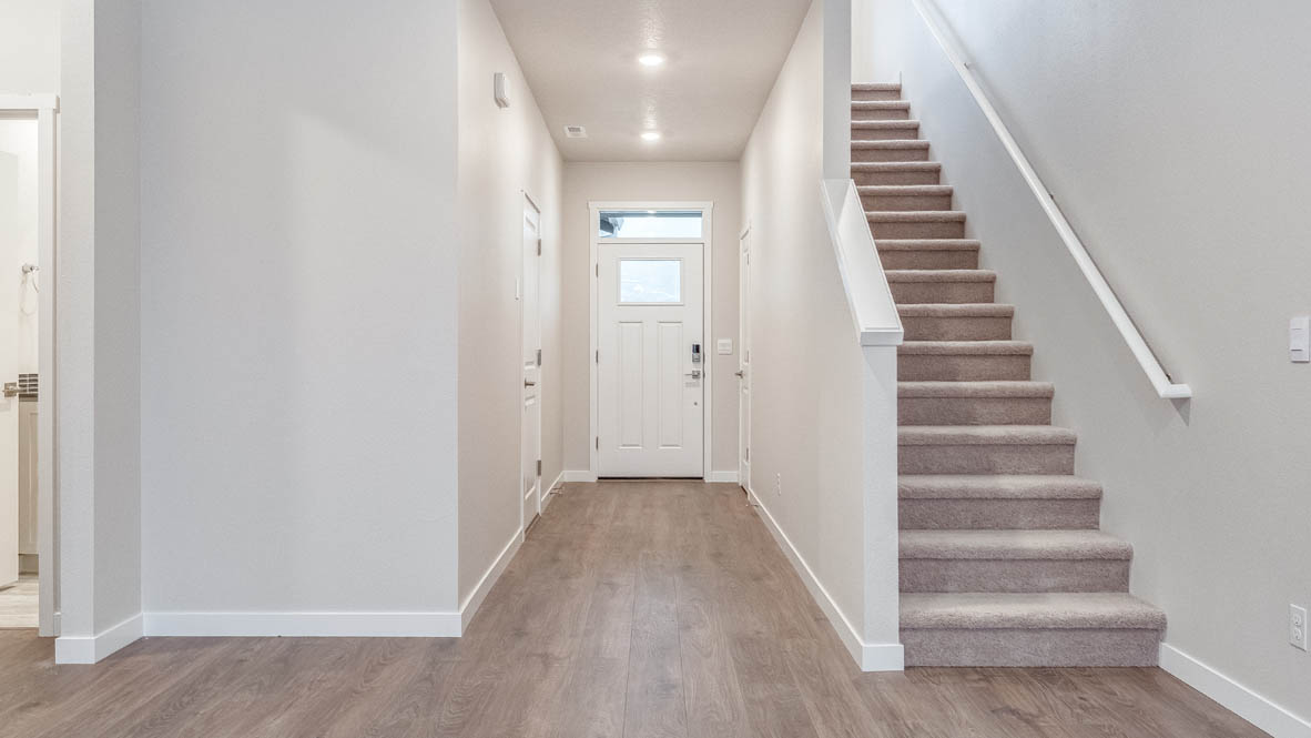 Avery Terrace Hallway with staircase, laminate flooring, and the bathroom in the background