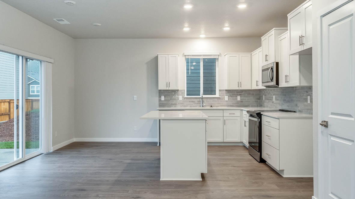 Avery terrace Kitchen with quartz countertops, island, stainless steel appliances, cabinets, and a window