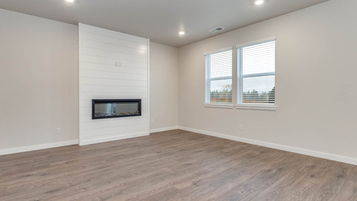 Avery Terrace great room with staircas, white walls, and fireplace