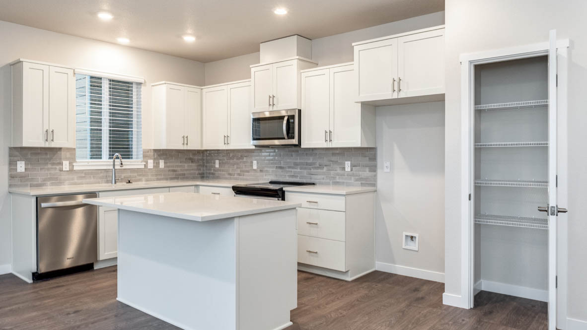 Avery terrace Kitchen with quartz countertops, island, stainless steel appliances, cabinets, and a window