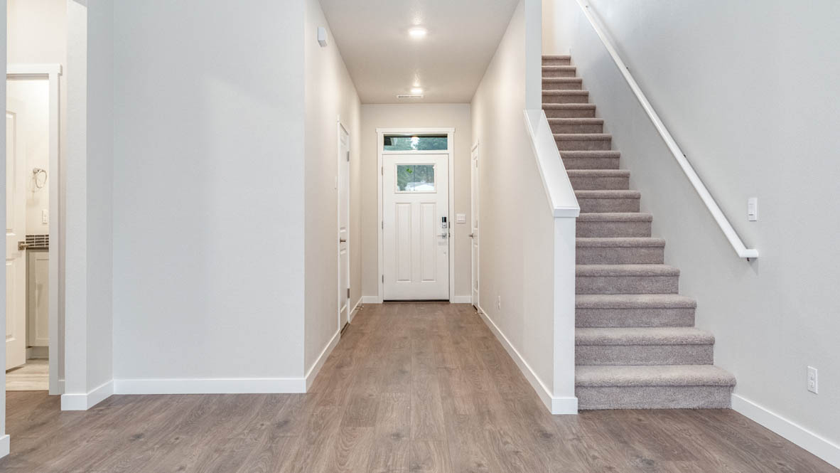 Avery Terrace Hallway with staircase, laminate flooring, and the bathroom in the background