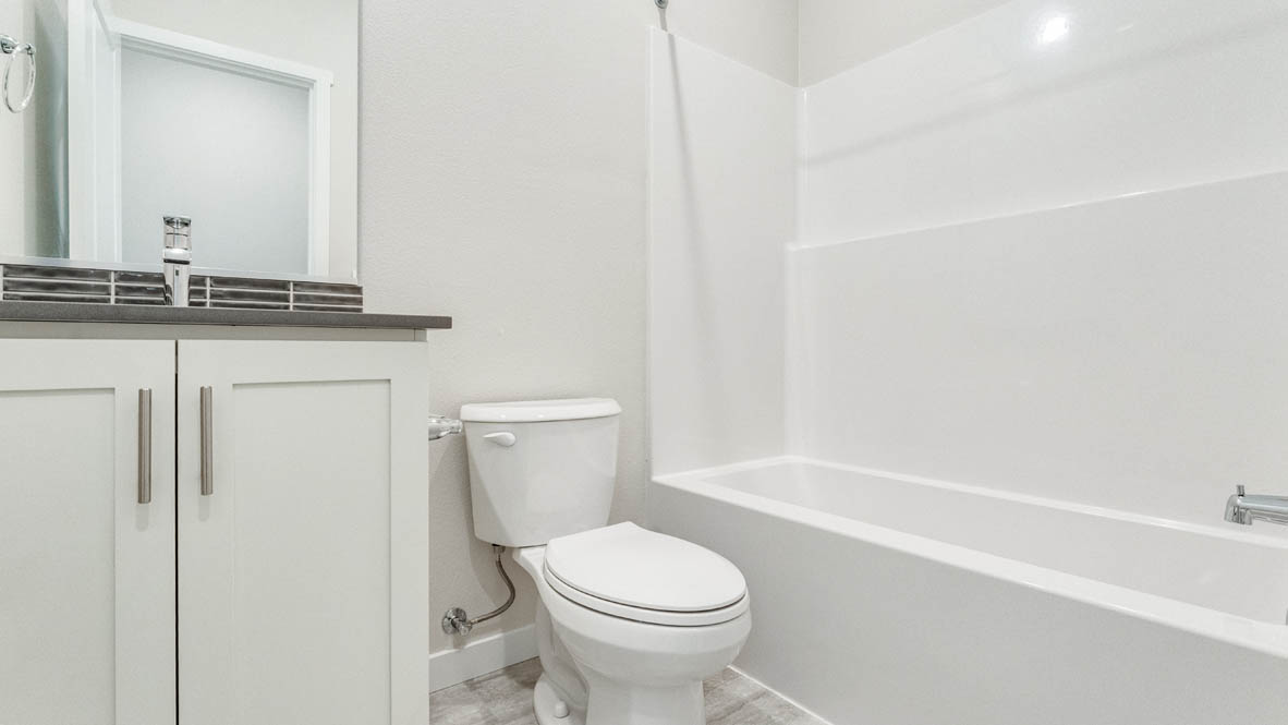 Avery terrace Bathroom with a mirror, shower tub, toilet, sink, quartz countertops, and sink