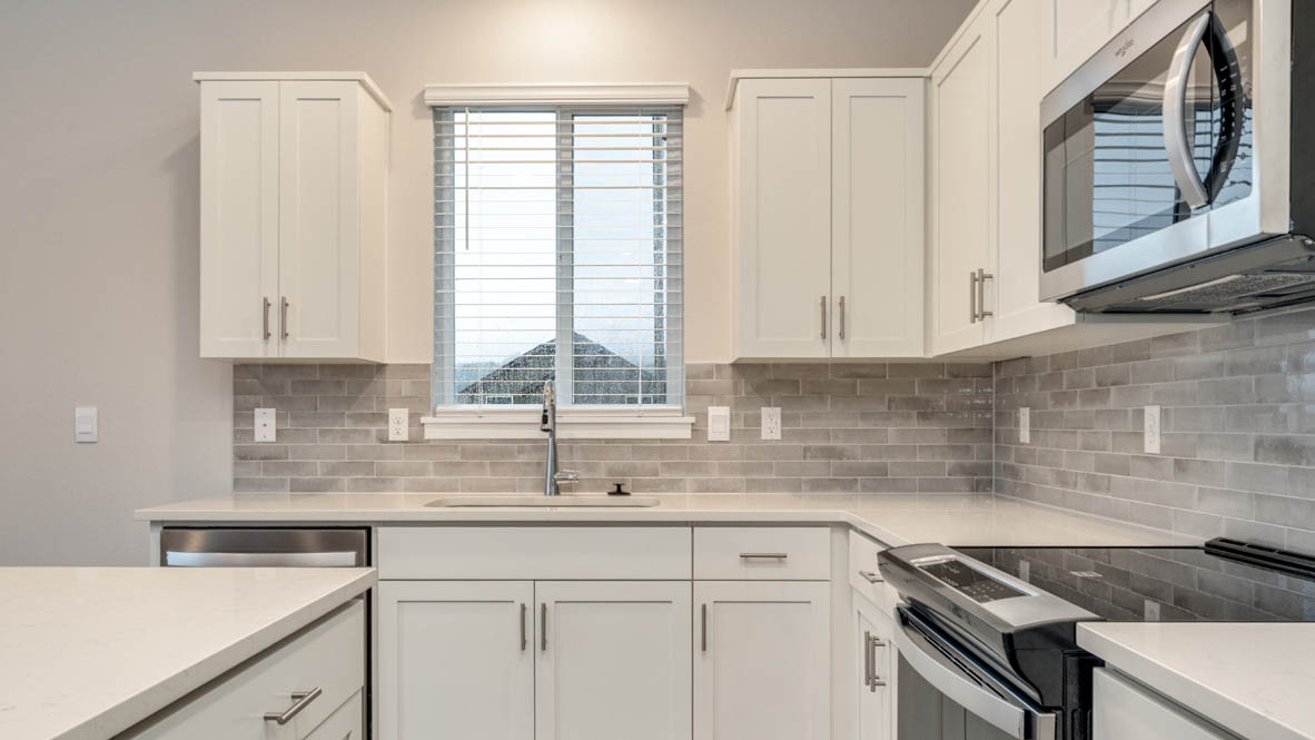 Avery terrace Kitchen with quartz countertops, island, stainless steel appliances, cabinets, and a window