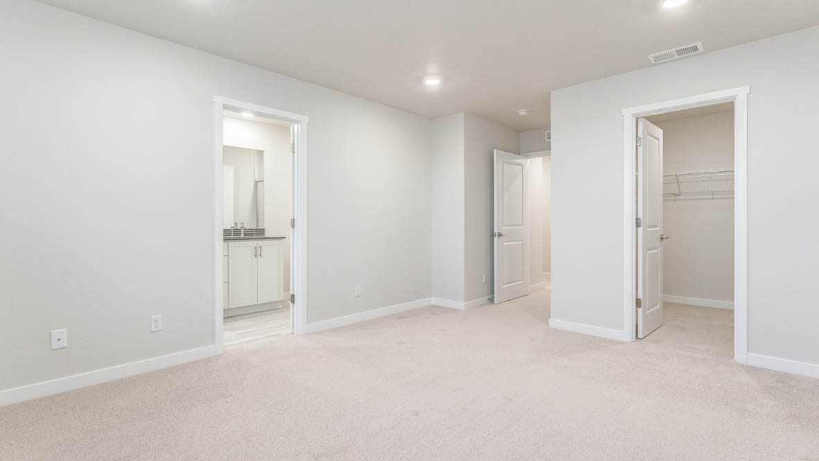 Avery Terrace primary bedroom with carpet, windows, and the en suite bathroom in the background