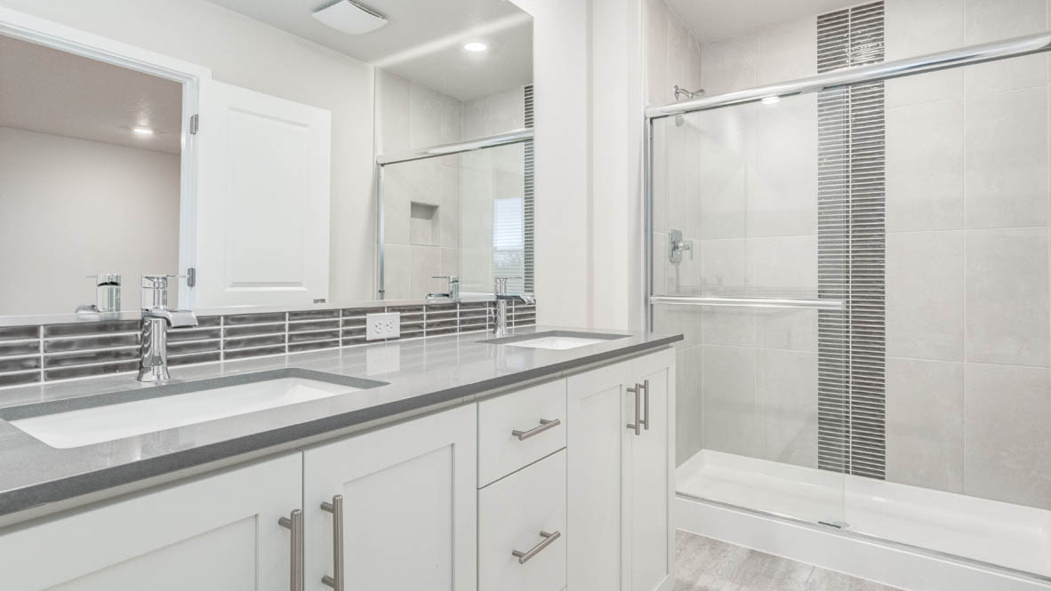 Avery Terrace primary bathroom with mirror, cabinets, walk in closet, solid surface countertops