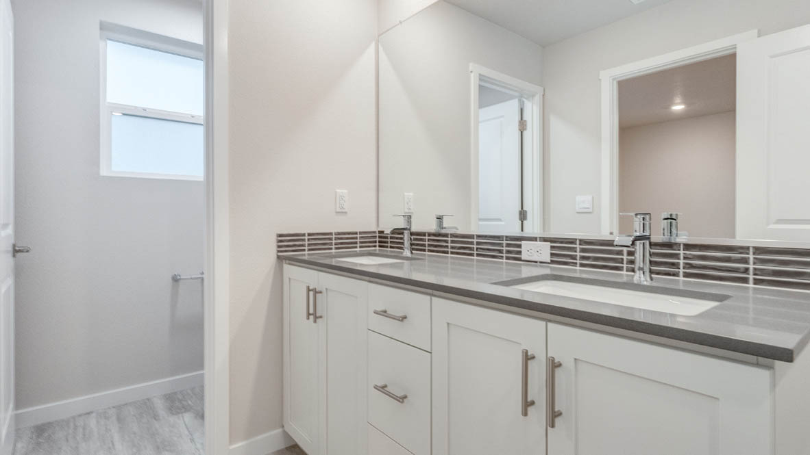 Avery Terrace primary bathroom with mirror, cabinets, walk in closet, solid surface countertops