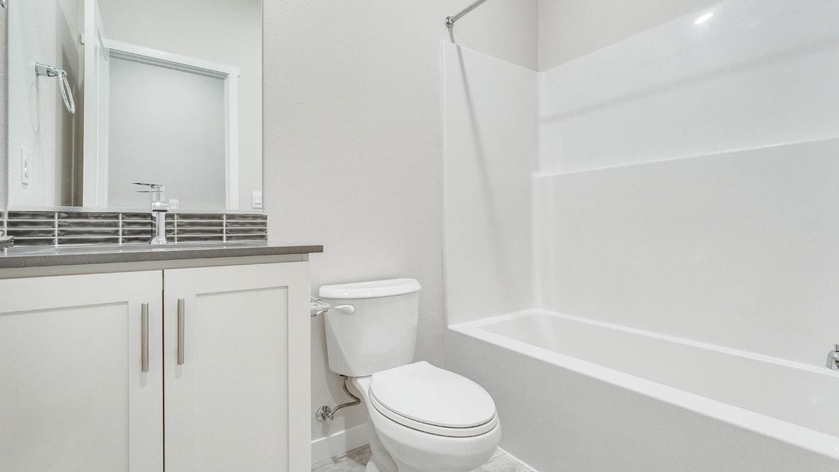 Avery terrace Bathroom with a mirror, shower tub, toilet, sink, quartz countertops, and sink