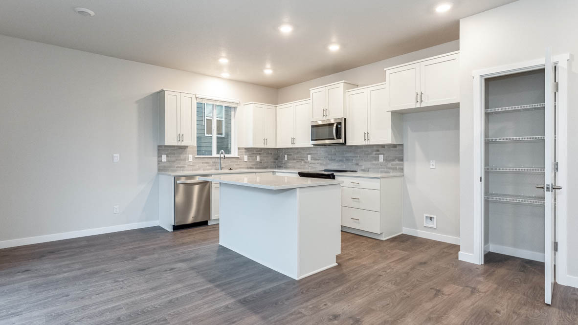Avery terrace Kitchen with quartz countertops, island, stainless steel appliances, cabinets, and a window