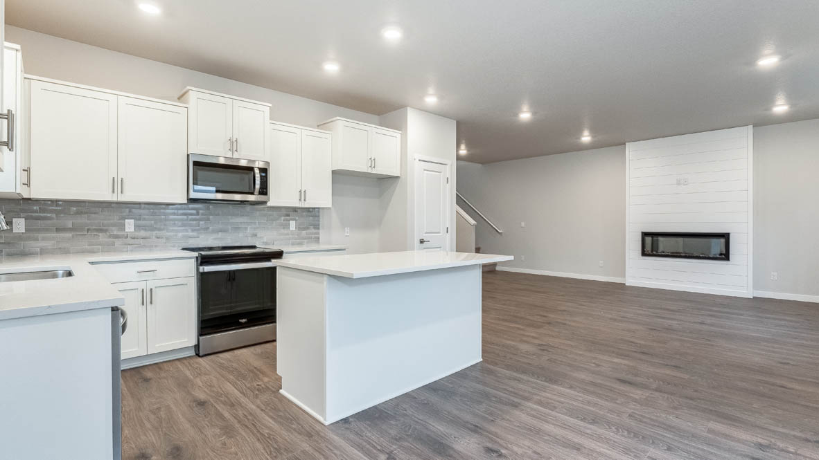 Avery terrace Kitchen with quartz countertops, island, stainless steel appliances, cabinets, and a window