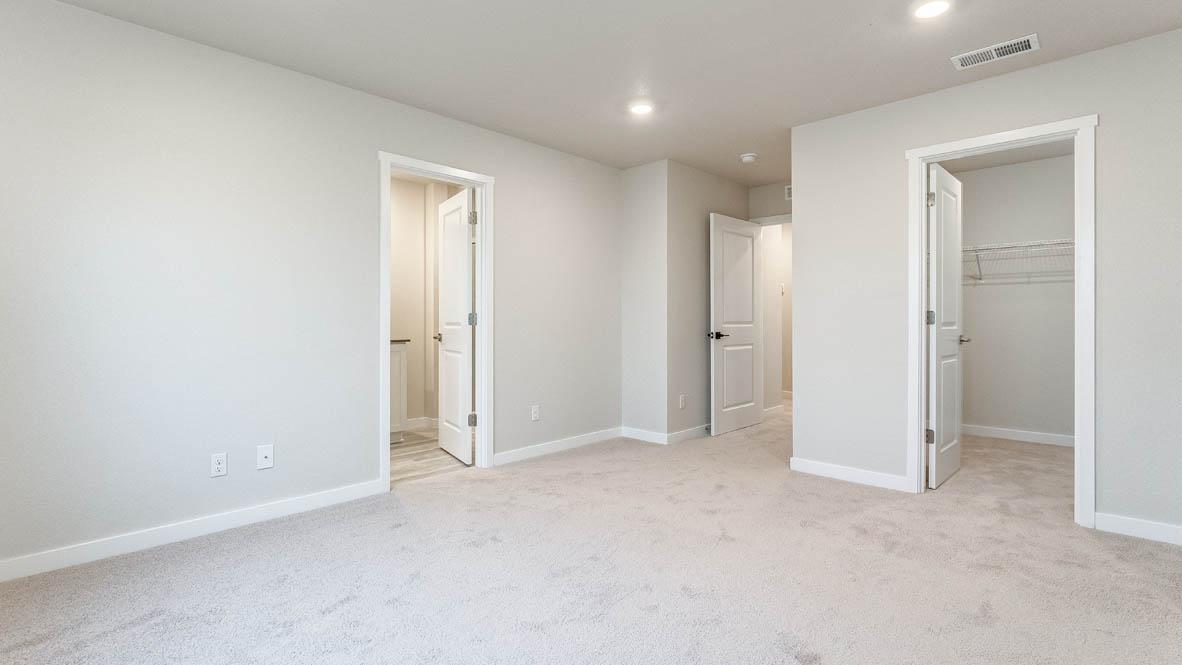 Avery Terrace primary bedroom with carpet, windows, and the en suite bathroom in the background