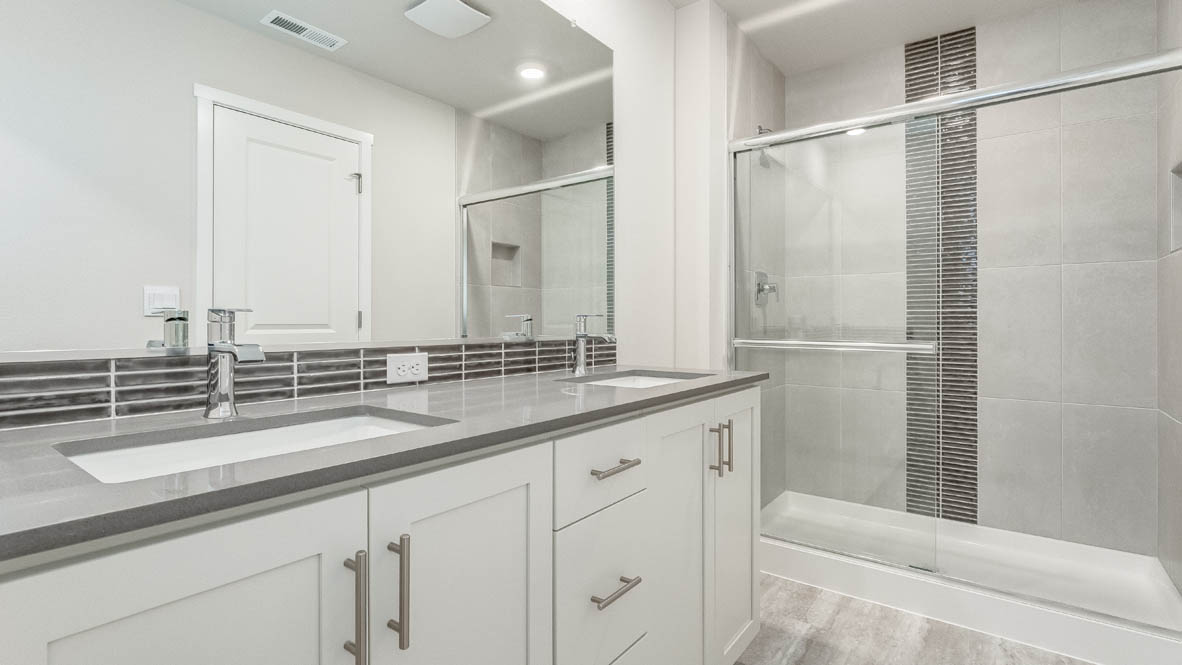 Avery Terrace primary bathroom with mirror, cabinets, walk in closet, solid surface countertops