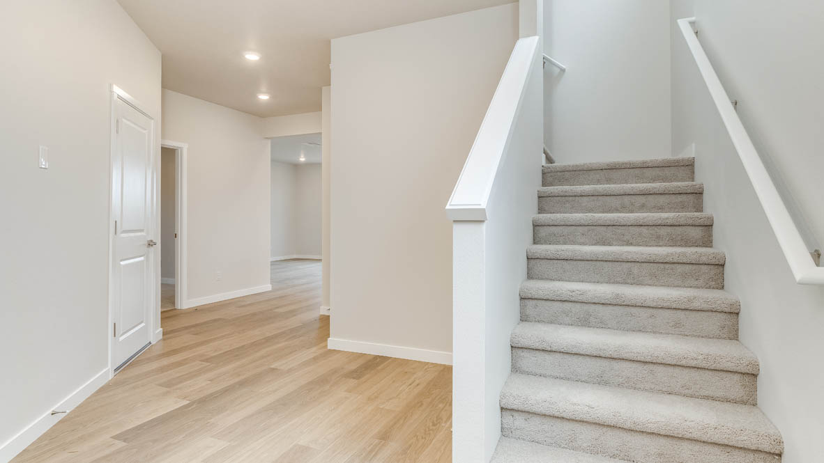 Avery Terrace entry door with laminate flooring and powder room, staircase