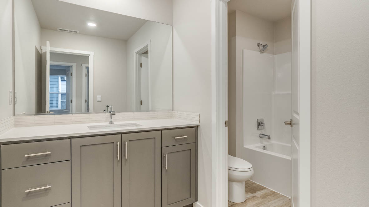 Hall bathroom with combination tub/shower and quartz counters