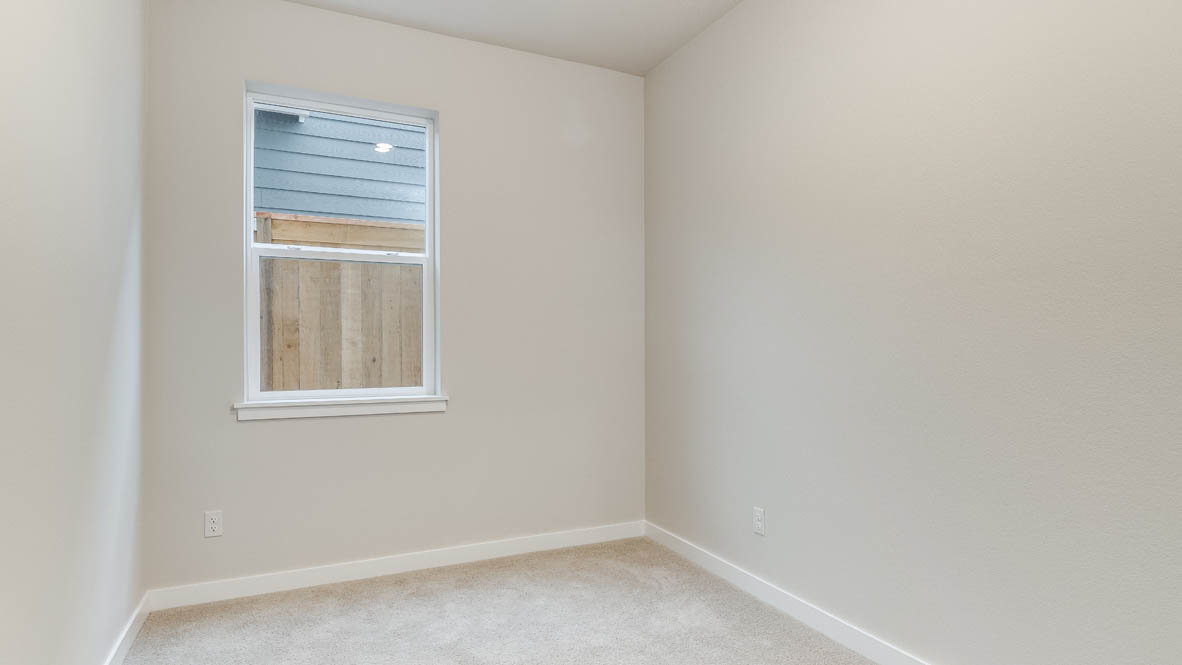 Avery Terrace den with carpet, white walls, and window