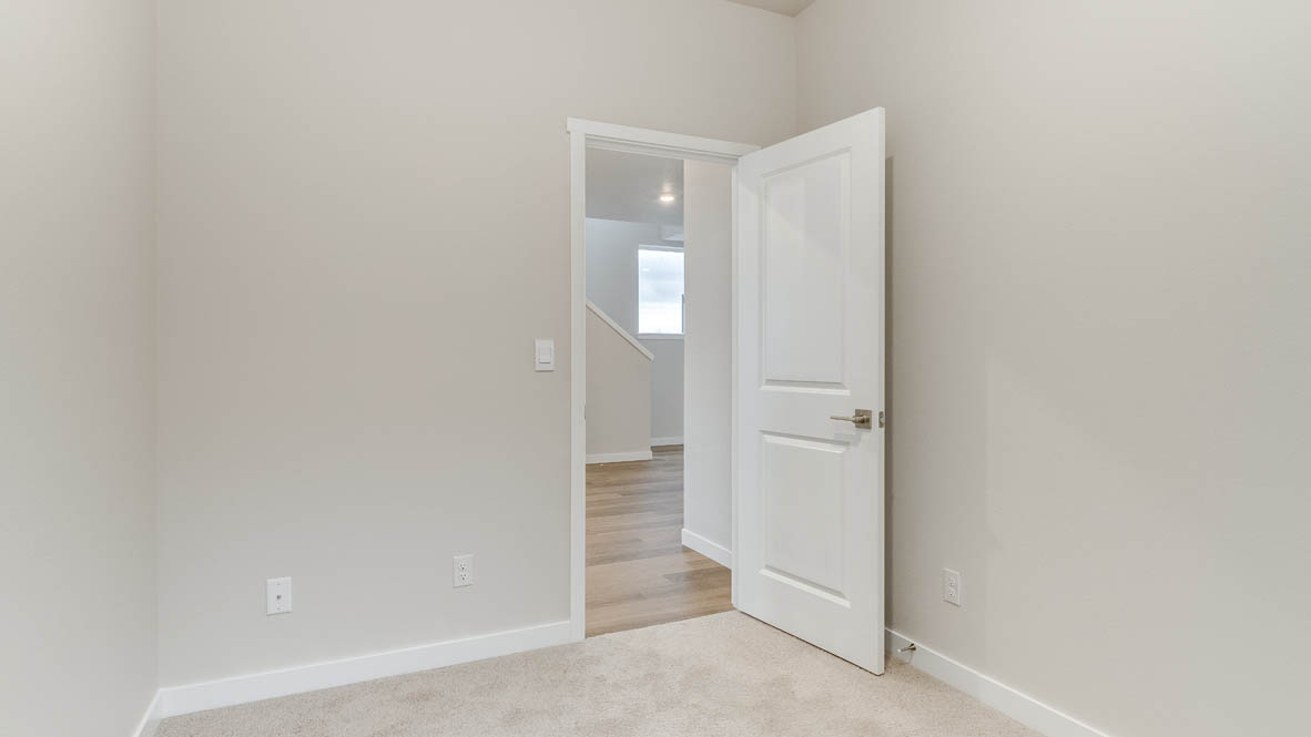 Avery Terrace den with carpet, white walls, and door