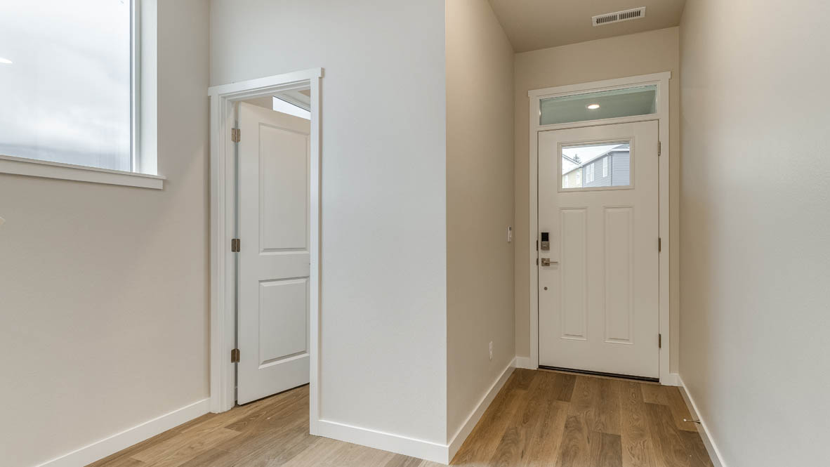 Avery Terrace entry door with laminate flooring and powder room, staircase