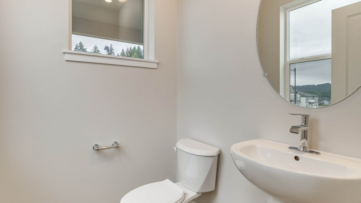 Avery Terrace powder room with mirror, toilet, window, and white walls