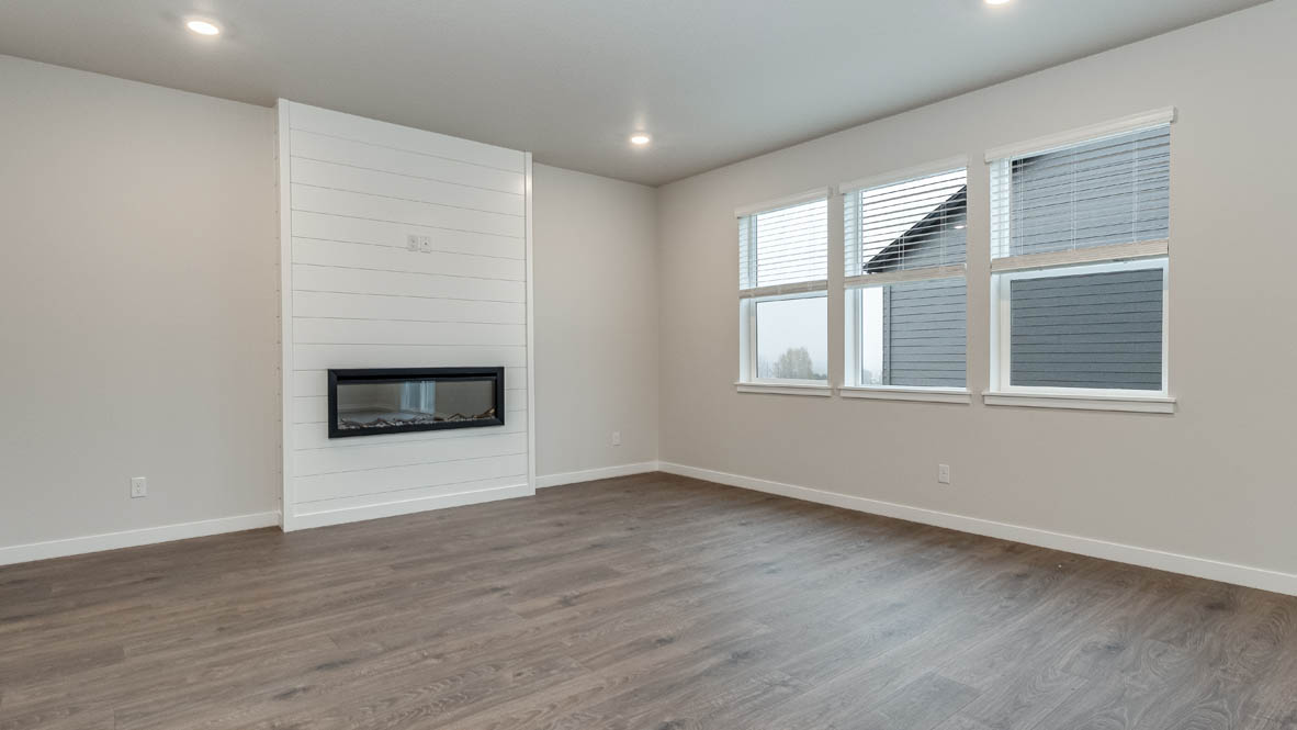 Avery Terrace great room with windows, white walls, and fireplace in the background