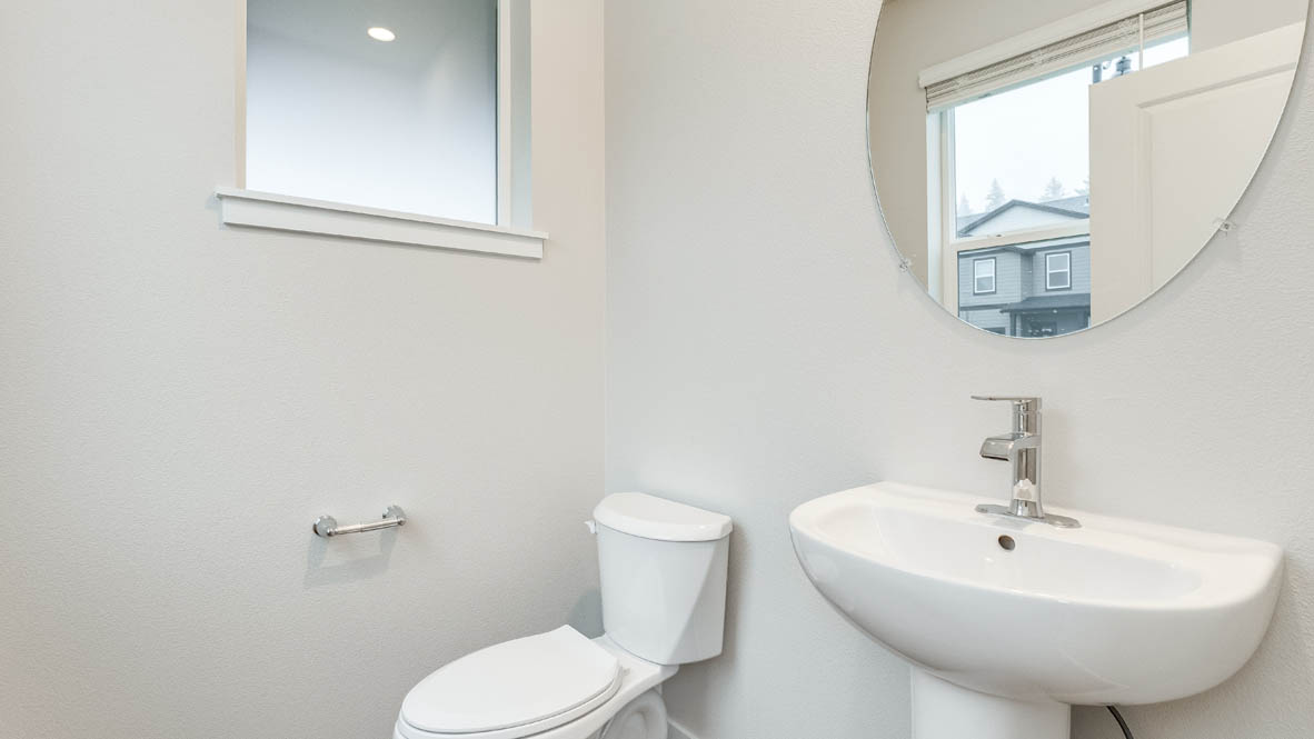 Avery Terrace powder room with mirror, toilet, window, and white walls