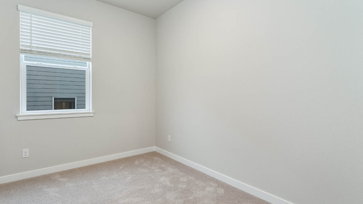 Avery Terrace den with carpet, white walls, and window
