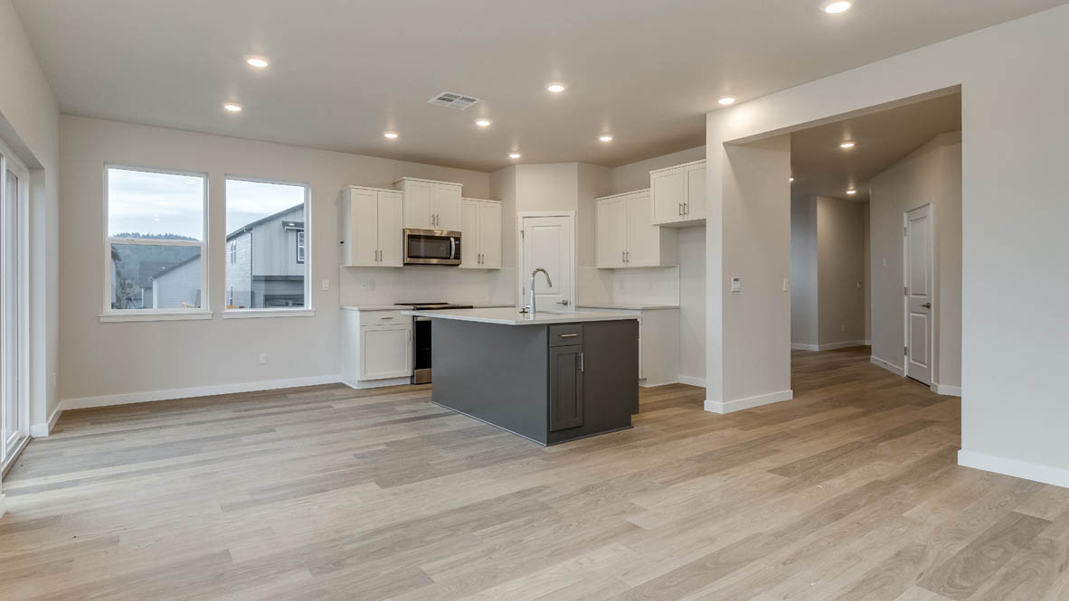 Avery terrace Kitchen with quartz countertops, island, stainless steel appliances, cabinets, and a window