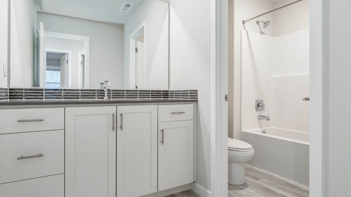 Hall bathroom with combination tub/shower and quartz counters