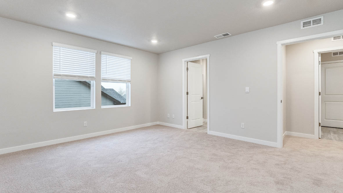 Primary bedroom with wall-to-wall carpet, a walk-in closet and an attached bathroom