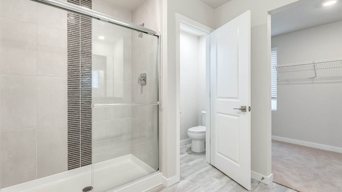 Primary bathroom with quartz counters and a walk-in shower