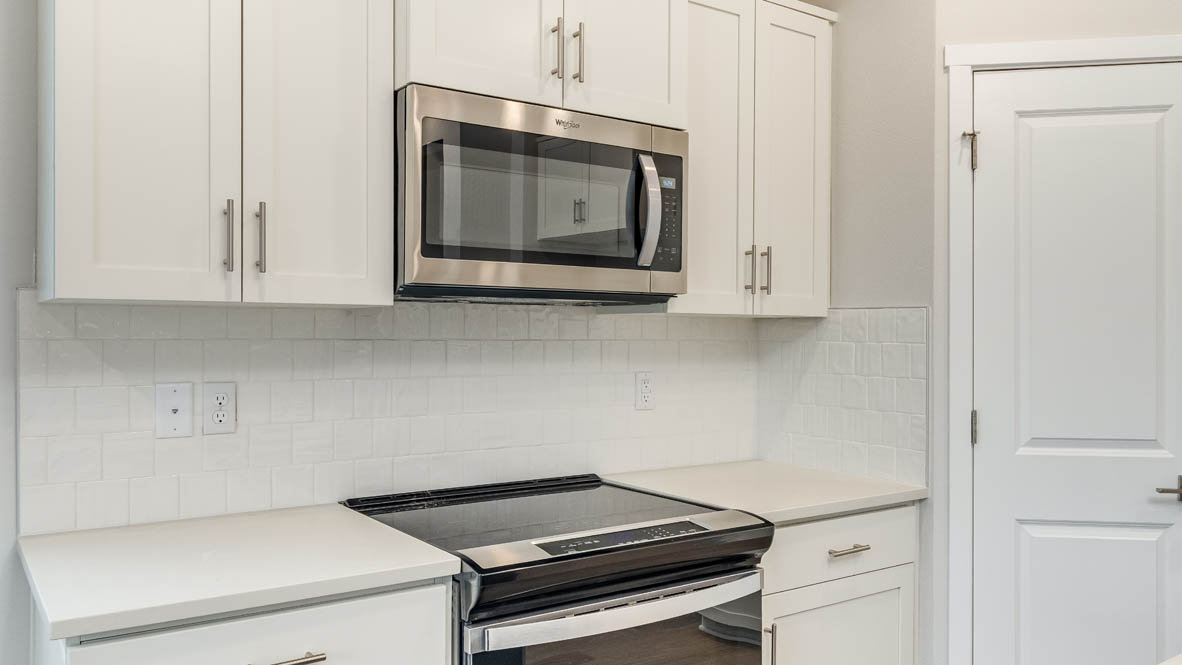 Avery terrace Kitchen with quartz countertops, island, stainless steel appliances, cabinets, and a window