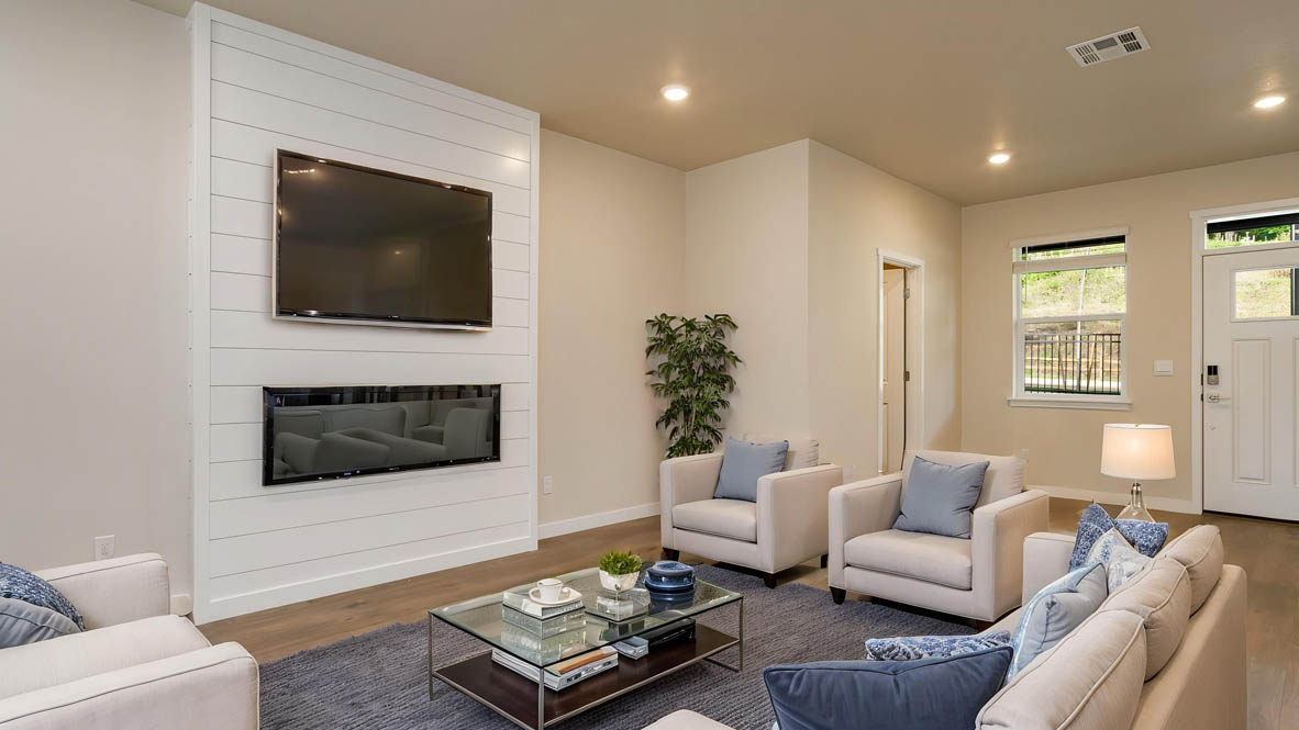 Avery Terrace Great room with large couch over a rug and surrounding a coffee table facing the fire place