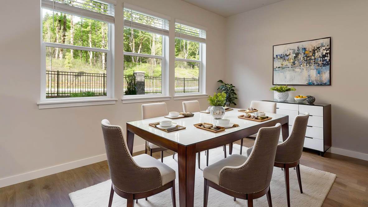 Avery Terrace Dining room with a table set for six chairs and the kitchen with stainless steel appliances