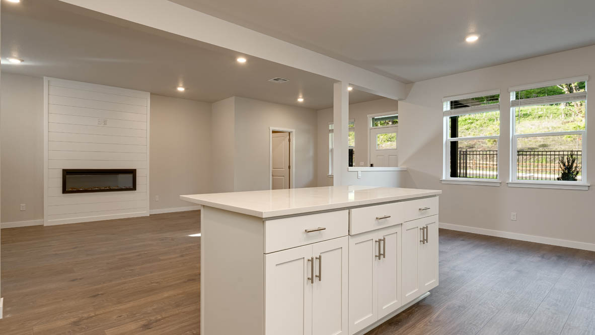 Kitchen with shaker cabinets, quartz counters, stainless steel appliances, pantry, and an island with a breakfast bar
