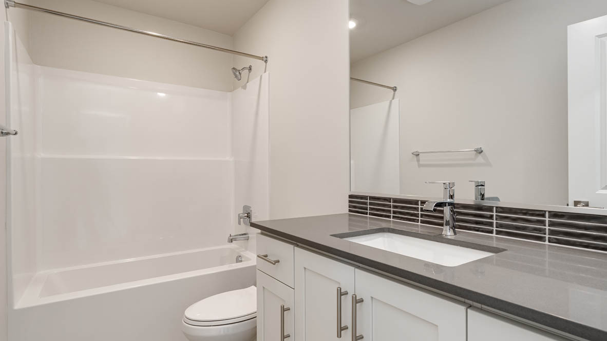 Hall bathroom with combination tub/shower and quartz counters